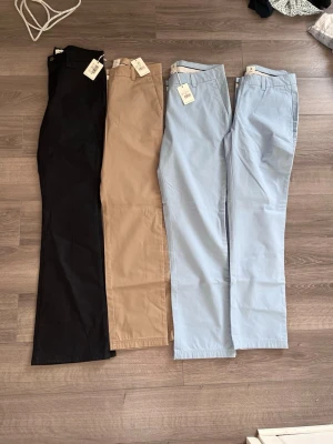 Chinos i svart, beige och ljusblå. 180kr st - Säljer tre par chinos från PPJ i färgerna svart, beige och ljusblå. Klassisk rak passform med hällor för bälte och fickor i sidorna. Perfekta för en stilren och avslappnad look. Materialet är mjukt och bekvämt bomullstyg.
