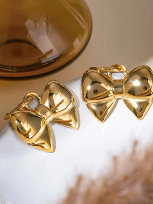 Rosett Örhängen i Stål med 18K Guld, Vattentålig - TINA - Smycket är hypoallergent och vattentåligt – perfekt för daglig användning, även i dusch, träning eller på resa och är lämpliga även för känslig hud.  Material: Rostfritt stål Plätering: 18k guldplätering (PVD) Vikt: 16-17 g