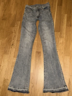 Blå utsvängda jeans med vintagekänsla - Jeansen sitter väldigt tight och skulle passa dig om du är kort, dem är även väldigt lowwaist. Snygga blå jeans med utsvängda ben och klassisk femficksmodell. Jeansen har en tvättad look med ljusa partier och normalhög midja. Perfekta för dig som gillar retrostil och vill sticka ut lite extra. 