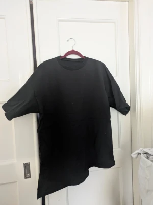 Svart t-shirt med slits  - T-shirt med slits, använd en gång, nyskick, kan användas som oversize, S-L 