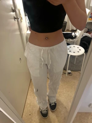 Vita linnebyxor från Gina Tricot - Säljer ett par vita linnebyxor från Gina Tricot med avslappnad passform och dragsko i midjan. Byxorna har resår i midjan och raka ben, perfekta för en chill och stilren look. Materialet är lätt och luftigt linne.