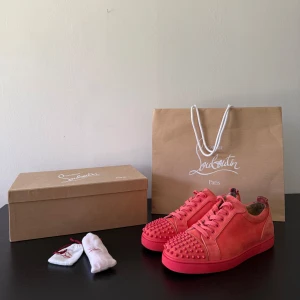 Christian Louboutin sneakers - Säljer ett par ovanliga orangea Louboutin Louis Junior Spikes Orlato Flat inköpta från butik i London!! Har endast gått i dem ett få antal gånger, och säljer på grund av att storleken inte var helt rätt. Jag fick skavsår, därav det enda slitaget vilket är märken från skavsåren, men ingenting som syns eller som man tänker på när man bär skorna. Går att se på första bilden.  Allt följer med förutom dustbags, som försvann när jag flyttade tyvärr, som plåster på såren följer en bag från butiken med.