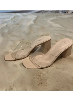 Beige pumps med transparent rem - Stilrena pumps från Duffy i beige med fyrkantig tå och bred transparent rem över foten. Skorna har en stadig blockklack och öppen design som ger en modern look. Perfekta för dig som gillar minimalistisk och trendig stil.