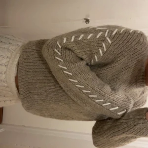Brunbeige stickad tröja med snörning - Supermysig beige stickad tröja med långärmad passform och cool vit snörning längs ärmarna. Tröjan har en loose fit och är perfekt för dig som gillar chill och stilren look. Materialet är mjukt och värmande, perfekt för kyliga dagar. Den är i storlek XS, och har aldrig använts (lapp kvar)! 