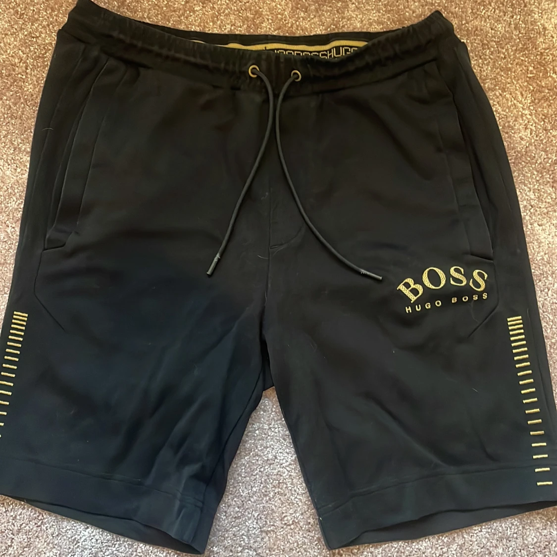 Svarta shorts från Hugo Boss med gul logga