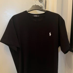 Svart t-shirt från Polo Ralph Lauren - Svart t-shirt från Polo Ralph Lauren i mjuk bomull. Använd en gång så ör helt ny!