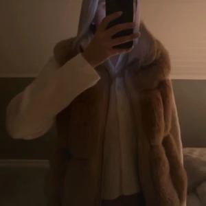 Beige pälsväst från Max & Moi - Supermjuk och fluffig beige pälsväst från Max & Moi med hög krage och dragkedja framtill. Västen har en cool quiltad look med breda paneler och ger en lyxig vibe till din outfit. Perfekt att slänga över en hoodie eller skjorta för extra stilpoäng.