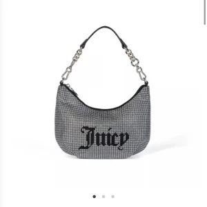 Juicy Couture glittrig axelväska silver - Glittrig axelväska från Juicy Couture i silver✨ Väskan har kedjehandtag, dragkedja och medföljande liten svart pouch. Insidan är fodrad med logomönster!! Köpte väskan för 1500, Nyskick💗
