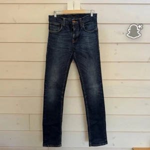 Nudie Jeans Grim Tim - Snygga mörkblå jeans från Nudie Jeans med klassisk femficksdesign och orangea sömmar på bakfickorna. Väldigt bra skick, modellen heter Grim Tim och storleken är 31/34.  Kom gärna med prisförslag och eller frågor// Loke