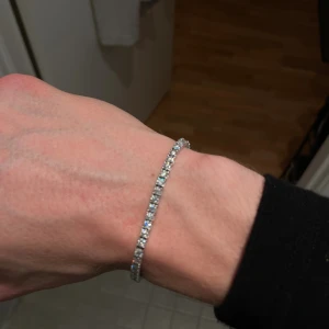 Moissanite tennis armband - Säljer mitt moissanite tennis armband. Stenarna är 3mm. Armbandet är helt i 925 silver och är 6.5 inches långt. Bilderna visar inte hur mycket stenarna dansar. Mycket fint och ögondragande. Kan filma video där jag testar det med en diamanttestare, alla stenar passerar. 