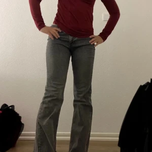 Gråa flared jeans - Snygga grå flared jeans med låg midja. De är i storlek 42 men det är lite sönder nere på en (sista bilden i annonsen) men annars inget som märks tänker jag💕pris kan diskuteras!