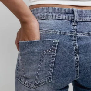 Blå bootcut jeans från ginatricot  - Snygga blå bootcut jeans från ginatricot och har en ljus tvätt. Jeansen är "ultra" low rise och ger mig en y2k look. Perfekt för dig som vill ha ett par jeans med lite utsvängda ben. Jag säljer de för de kommer aldrig till användning jag har max använt de 1 gång. Tvättade innan leverans. Original pris❤️