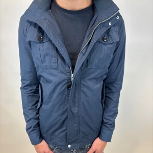 J.Lindeberg Jacka  - Hej! Säljer nu denna väldigt snygga och eftertraktade J.Lindeberg Fieldjacka!  Jackan är slutsåld överallt och går inte att få tag på… jackan är perfekt nu till hösten/vintern  Storlek M  Skick 8/10 (knappar saknas) Ny pris: 6000 kr Säljs för: 1499 kr