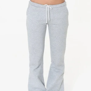 Grå mjukisbyxor från nitted low waist  - Snygga ljusgrå mjukisbyxor med bootcut och dragsko i midjan. Byxorna har en relaxed passform och är tillverkade i mjuk bomullsmix som känns skön mot huden. Perfekta för chill dagar eller när du vill ha en avslappnad look. Passar s-m är storlek m men passar s 