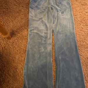 Två par mjukisbyxor i blått och beige - Säljer två par mjukisbyxor med , ett par i ljusblått och ett i beige.  Hon har inte använt mycket på grund av hon har blivit stor St 100 hör av er gärna 