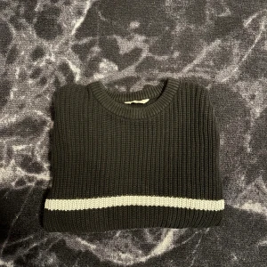 Svart stickad tröja med vita ränder - Säljer en svart stickad tröja med vita horisontella ränder. Tröjan har rund halsringning och långa ärmar. Perfekt för kyligare dagar och enkel att matcha med jeans. Hör gärna av er vid frågor eller funderingar 