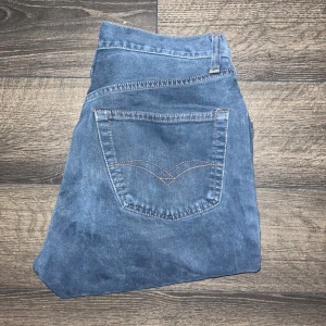 Replay jeans  - Säljer ett par klassiska replay jeans i blå denim. Jeansen har hög midja, raka ben och femficksmodell med snygga sömmar på bakfickorna. Midja 36cm, längd 100cm. Ifall det inte finns någon bild i annonsen där jag bär plaggen jag säljer så är det för att jag ej kan ha storleken heller passformen, så kolla måtten för storlek och googla på modellnamnet för passform 😉 s2