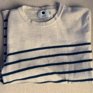 Randig merinoullströja från NN07 - Tjena! Säljer en skön randig tröja från NN07 i 100% merinoull. Knappt använd men väldigt liten i storleken, sitter mer som en liten xs men det står S i tröjan