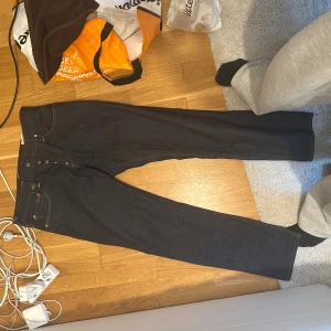 Evisu No. 3 jeans med vit målning 32x34 - Unika mörkblå jeans från Evisu, modell No. 3, med klassisk vit handmålad seagull-design och röda blommor på baksidan. Raka ben, femficksmodell och detaljer i kopparfärg. Tillverkade i kraftig denim från Osaka, Japan.