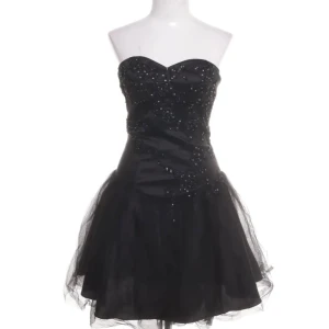 Svart klänning - Svart axelbandslös kort klänning med glittriga paljettdetaljer och tyllkjol. Klänningen har en dragkedja i ryggen. Perfekt för dig som vill sticka ut med en elegant och glamorös look💕