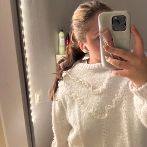 Vit stickad tröja med spetsdetaljer - Superfin vit stickad tröja med spetsvolanger. Skönt material och sticks inte.