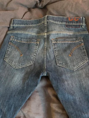 Dondup George - Snygga blå jeans med klassisk femficksdesign och kontrastsömmar på bakfickorna. Jeansen har en rak passform och normal midja. Perfekta till en avslappnad stil och funkar året runt.