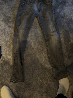 Replay Anbass slim fit jeans grå - Säljer ett par grå Replay Anbass slim fit jeans med klassisk femficksdesign och snygga slitningar. Jeansen har smal passform och är tillverkade i mjukt jeanstyg som sitter skönt hela dagen. Perfekta för dig som gillar en stilren och modern look.ny pris är 1299 säljer för 199