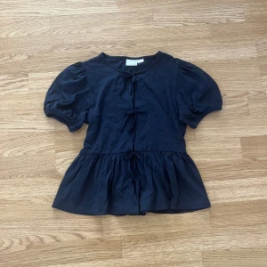 Mörkblå topp - Supersöt puff ärmad topp med volanger och rosetter, från Gina tricot. 
