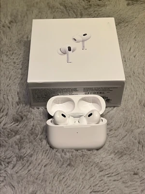 Trådlösa Hörlurar  - Säljer ett par vita  AirPods Pro med laddningsetui. De har en stilren och kompakt design med silikonproppar för extra komfort.  Kommer med USB c och hör proppar finns olika smarta inställningar 