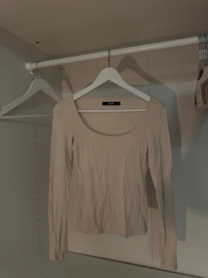 Krämvit långärmad topp från BikBok - Säljer en enkel och stilren cremevit långärmad topp från BikBok. Toppen har en djup rundringning och är tillverkad i ett mjukt bomullsmaterial som är så så skönt🙏🏼 Perfekt att matcha med jeans eller kjol för en clean look.
