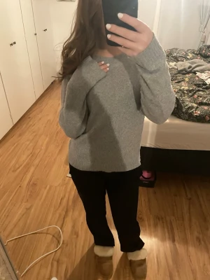 Ljusgrå stickad tröja - Mysig ljusgrå stickad tröja med avslappnad passform och långa ärmar. Tröjan har ribbade muddar vid ärmslut och nederkant. Passar till både jeans och mjukisbyxor.