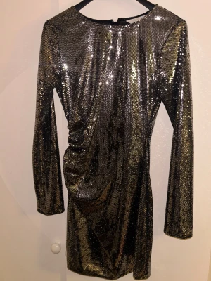 Glittrig klänning - Fin festklänning. Några paljetter har lossnat på några ställen (se bild två) , men det är inget man tänker på när den sitter på. Priset är diskuterbart!🫶