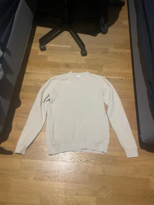 Beige stickad tröja från Selected Homme - Snygg beige stickad tröja från Selected Homme med rund halsringning och långa ärmar. Tröjan har en enkel och stilren design med ribbade muddar vid ärmslut och nederkant. Perfekt att matcha med jeans eller chinos. Pris kan diskuteras, skriv gärna.