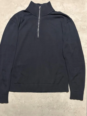 Massimo Dutti quarterzip  - Sällsynt Massimo Dutti quarterzip, Storlek M. Svart färg med lite bakgrund av marinblå, perfekt för dig som gillar en clean look och vill ha något bekvämt och snyggt.