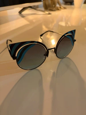 Fendi glasögon - Säljer ett par Fendi glasögon värda runt 5000. Dock har en liten liten skruv lossnat som ni ser på sista bilden, därav priset. Nytt skick förutom skruven.