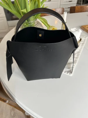 Acne Musubi väska svart - Hej! Säljer min svarta acne Musubi väska som jag haft ett tag nu men sparsamt använt den, inga märken eller repor samt fläckar! Mestadels stått hemma☺️kan gå ner i pris vid snabb affär💕