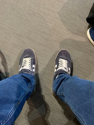 mörkblå Legends - Mörkblå legends sneakers i mocka med vita ränder på sidorna och vit snörning. Skorna har en klassisk låg siluett och gummisula i beige. Perfekta för en avslappnad och sportig stil. Nypris 1500 säljes billigt eftersom skokartongen osv är borta 