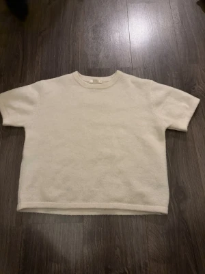 Beige stickad t-shirt Gina Tricot - Beige stickad t-shirt från Gina Tricot med korta ärmar.