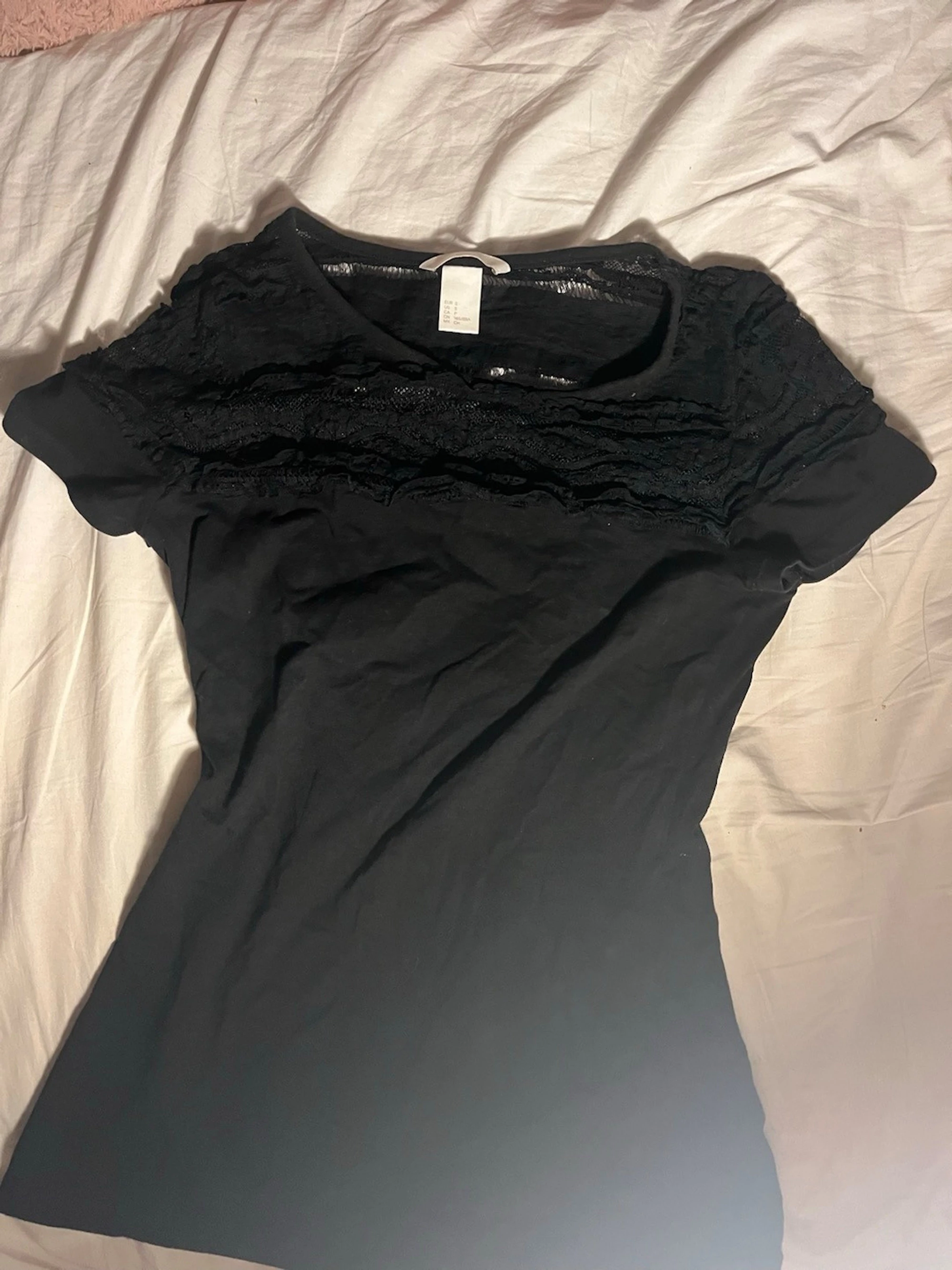Svart topp med spetsdetaljer