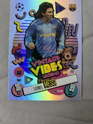 Match Attax Vintage Vibes Messi-kort - Säljer ett glittrigt samlarkort från Topps Match Attax med motiv av Lionel Messi i Barcelona-tröja. Kortet har texten 'Vintage Vibes Legend' och färgglada retrodetaljer. Perfekt för dig som gillar fotboll och samlarkort. Köparen står för frakten.