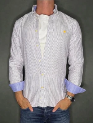 Randig skjorta från Morris - Snygg skjorta från Morris med smala svarta och vita ränder, klassisk button down-krage och gul broderad logga på bröstet. Nypris:1200Kr, Mitt pris:349Kr