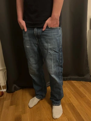 Blå jeans loose fit - Säljer ett par klassiska blå jeans från Jack and Jones med loose fit. Jeansen har rak passform, normal midja och är tillverkade i slitstarkt denim. Perfekta för dig som gillar en avslappnad stil och vill ha ett par tidlösa jeans i garderoben.
