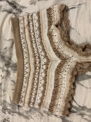 Beige och vit stickade shorts Divided - Supersöt stickade shorts från Divided i beige och vitt med vågiga kanter och hålmönster. Kortare modell med ribbad nederkant och mjukt bomullsmaterial. Perfekt för vår och sommar när du vill ha en chill och söt look.