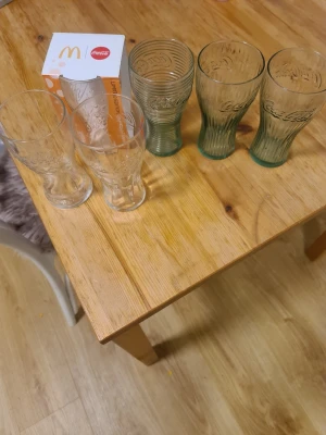 Coca-Cola glas från McDonald's - Säljer sex Coca-Cola glas från McDonald's i olika nyanser av klart och grönt glas. Glasen har den klassiska Coca-Cola-loggan och unik form. Perfekta för dryckessamlingen eller till vardags. En originalförpackning medföljer.