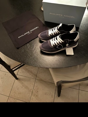Philippe Model trainers 👟  - Snygga sneakers från Philippe Model i marinblått och vitt med vita snören och detaljer. Materialmix av mocka och syntet för en modern look. Perfekta för dig som gillar stilrena och trendiga skor. Använd fåtal gånger. Nypris 3000