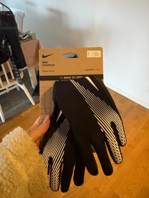 Svarta Nike handskar i junior storlek  - Svarta träningshandskar från Nike helt oanvända i junior storlek. Storlek L i junior storlek. Ny pris 279kr