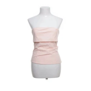 Ljusrosa tubtopp från Zara - Säljer en ljusrosa tubtopp från Zara i storlek S. Toppen är axelbandslös med en snygg omlottliknande drapering framtill och dragkedja bak. Perfekt att styla med jeans eller kjol för en trendig look.🥰🩷