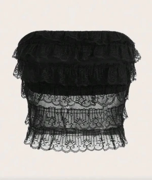 Snygg svart spets topp  - Säljer en svart spets topp med flera lager volanger. Toppen är transparent nedtill och är super snygg till middag eller fest! Köpt vintage men säljer för den inte kommit till bra användning 