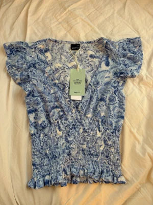 Blå vit blus från Gina - Supersöt blå vit blus från Gina. Helt ny och säljer då den ej kommit till användning. 