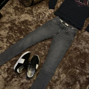 Grå slim fit jeans från Selected Homme - Säljer ett par snygga grå slim fit jeans från Selected Homme. De är i 100% ekologisk bomull, vilket gör dem både bekväma och miljövänliga. Perfekta för både vardag och fest! Sick 10/10 storlek 29/32 ny pris ca 1100